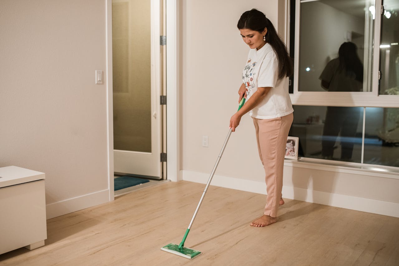 digital Woman cleaning a room with a mop, demonstrating domestic chores in a minimalist indoor setting.